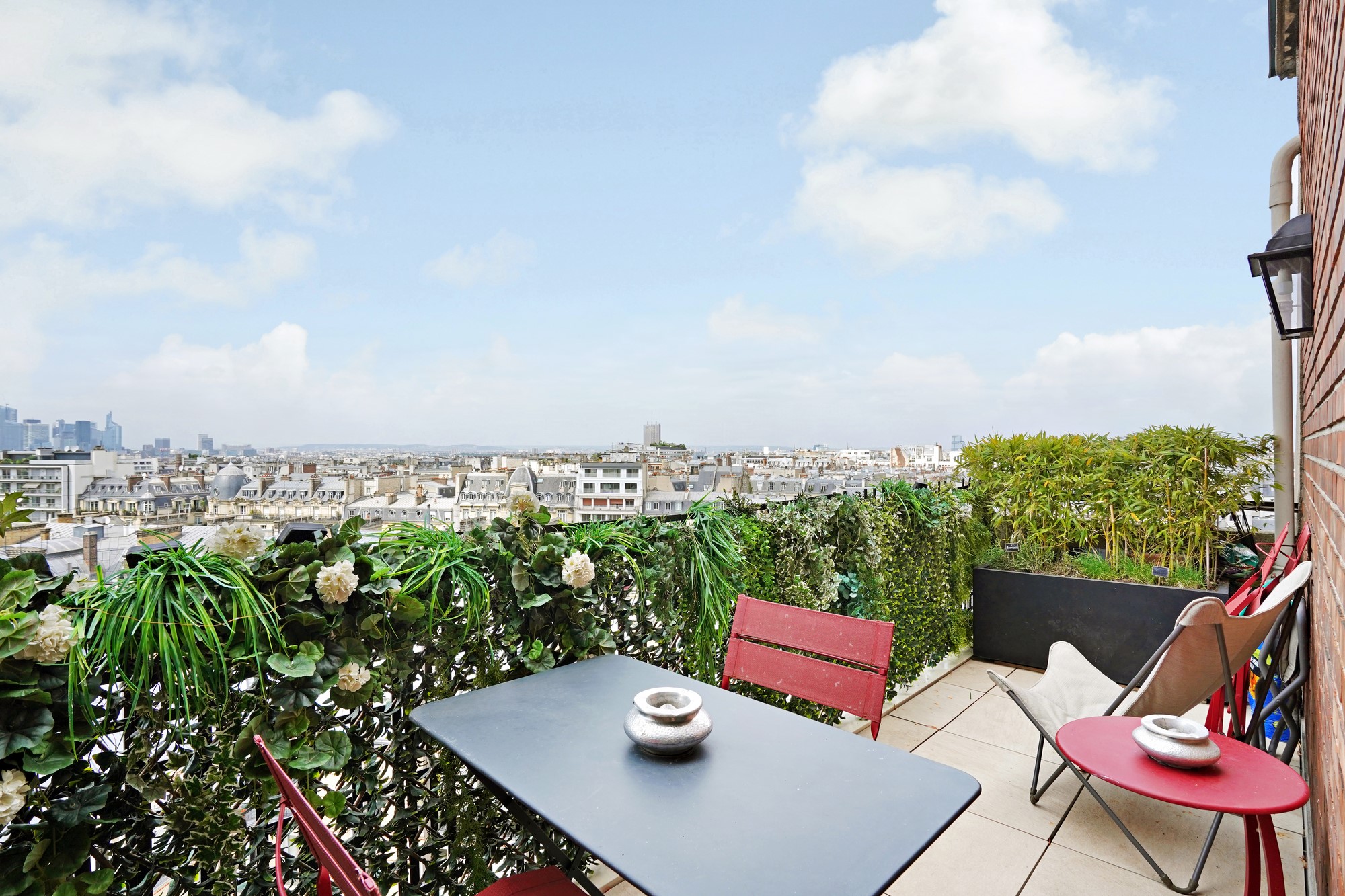 Terrasse avec coin repas et vue dégagée sur Paris, Montmartre et la Défense