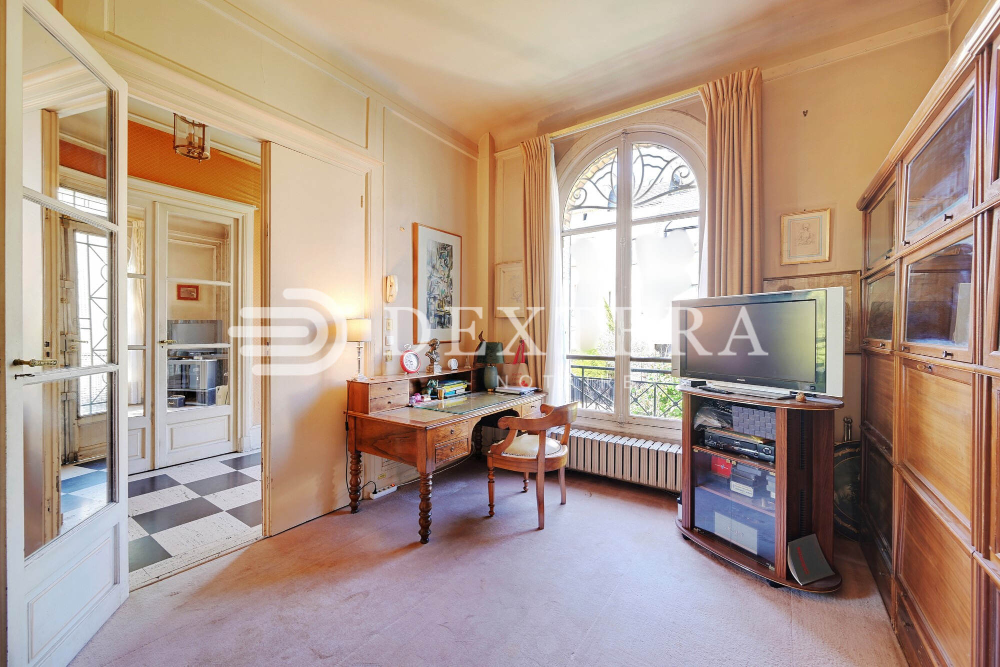 Hôtel Particulier à Neuilly-sur-Seine : Bureau avec grande fenêtre cintrée, moulures murales et vue sur la voie privée.