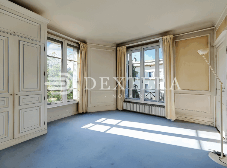 Hôtel Particulier à Neuilly-sur-Seine : Grande chambre d’angle avec fenêtres sur deux façades et placards moulurés.