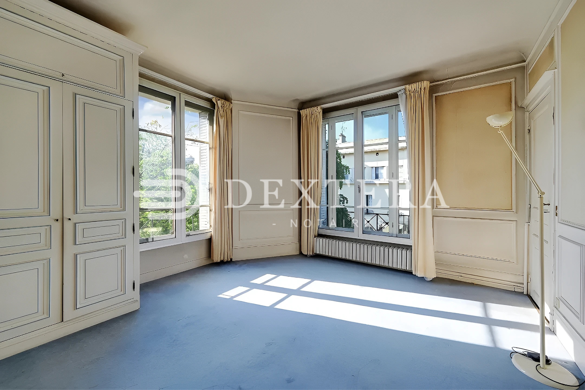 Hôtel Particulier à Neuilly-sur-Seine : Grande chambre d’angle avec fenêtres sur deux façades et placards moulurés.