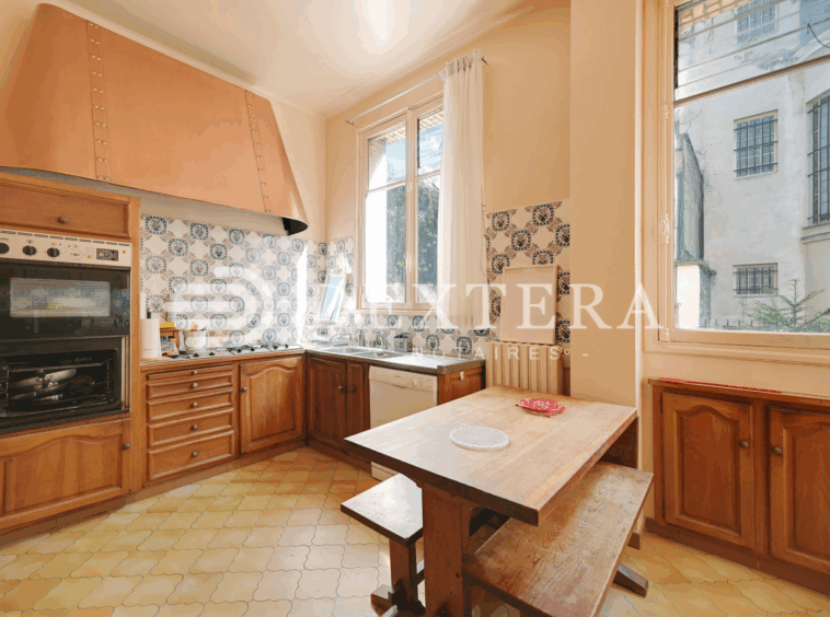 Hôtel Particulier à Neuilly-sur-Seine : Cuisine indépendante de 15 m² avec éléments anciens en bois et coin repas intégré.