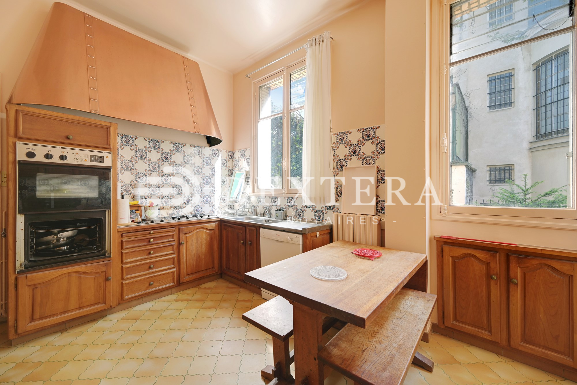 Hôtel Particulier à Neuilly-sur-Seine : Cuisine indépendante de 15 m² avec éléments anciens en bois et coin repas intégré.