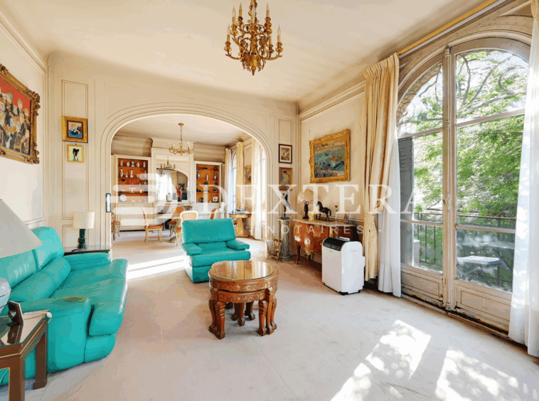 Hôtel Particulier à Neuilly-sur-Seine : Double séjour lumineux avec grandes fenêtres cintrées et parquet point de Hongrie dans un hôtel particulier à Neuilly-sur-Seine.