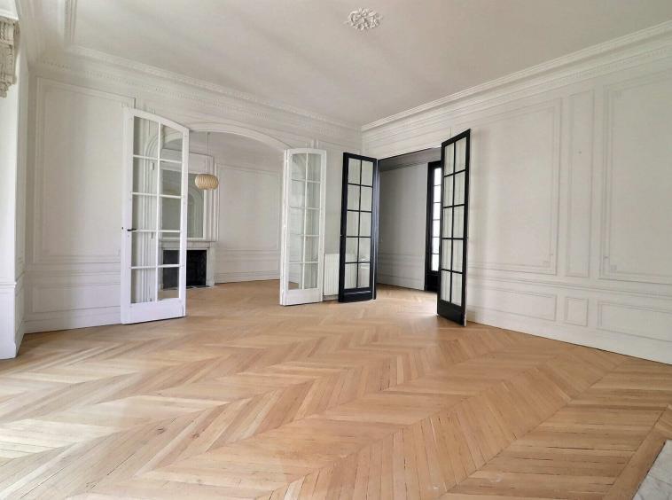 Salon avec parquet en point de Hongrie et portes vitrées dans un appartement haussmannien à Neuilly-sur-Seine, quartier Roule