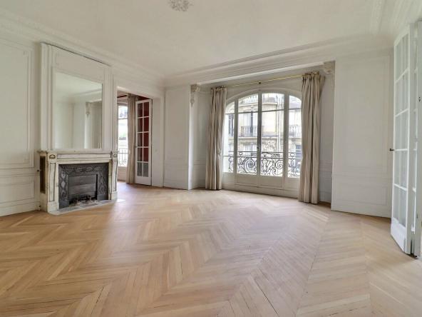 Salon lumineux avec parquet point de Hongrie et cheminée dans un appartement haussmannien à Neuilly-sur-Seine
