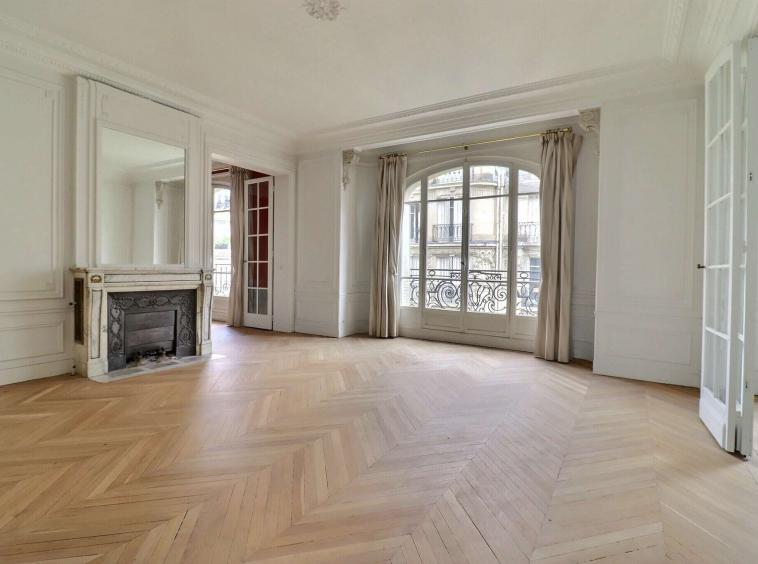 Salon lumineux avec parquet point de Hongrie et cheminée dans un appartement haussmannien à Neuilly-sur-Seine