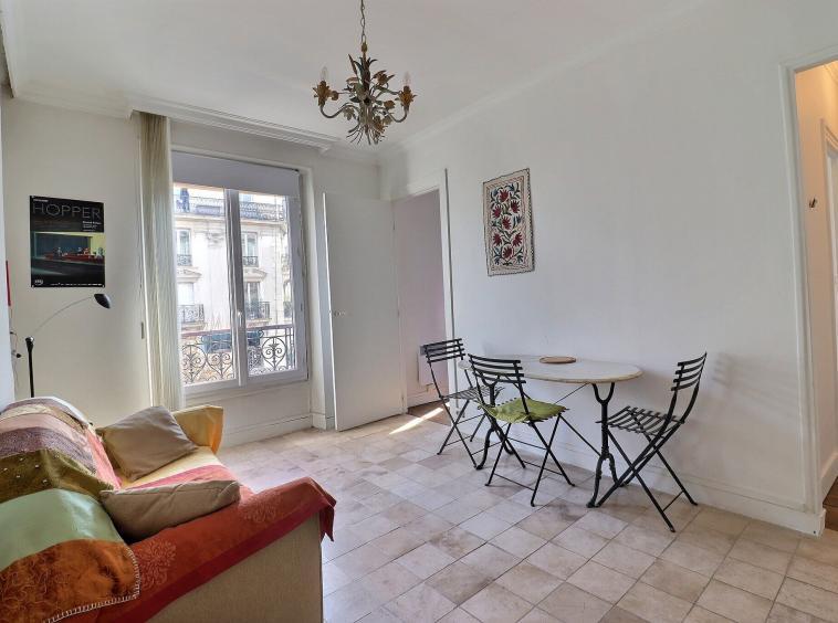 Séjour traversant avec coin repas et fenêtre sur rue, appartement 2 pièces Paris 12