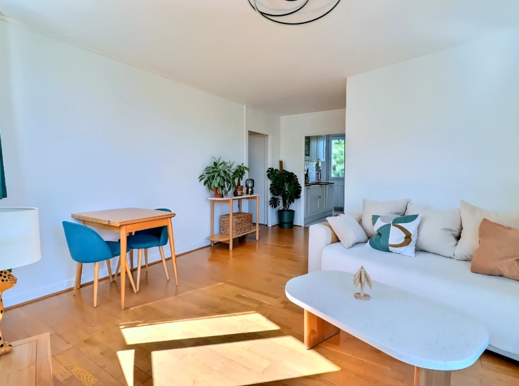Séjour avec canapé blanc, table à manger et parquet dans un appartement 4 pièces à Meudon Val-Fleury