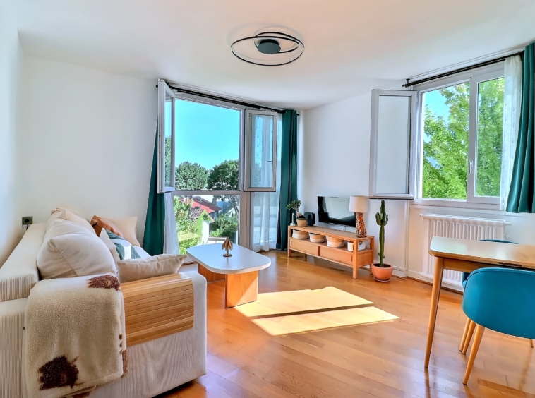 Séjour lumineux d’un appartement à Meudon Val-Fleury avec deux grandes ouvertures et vue dégagée sur la verdure