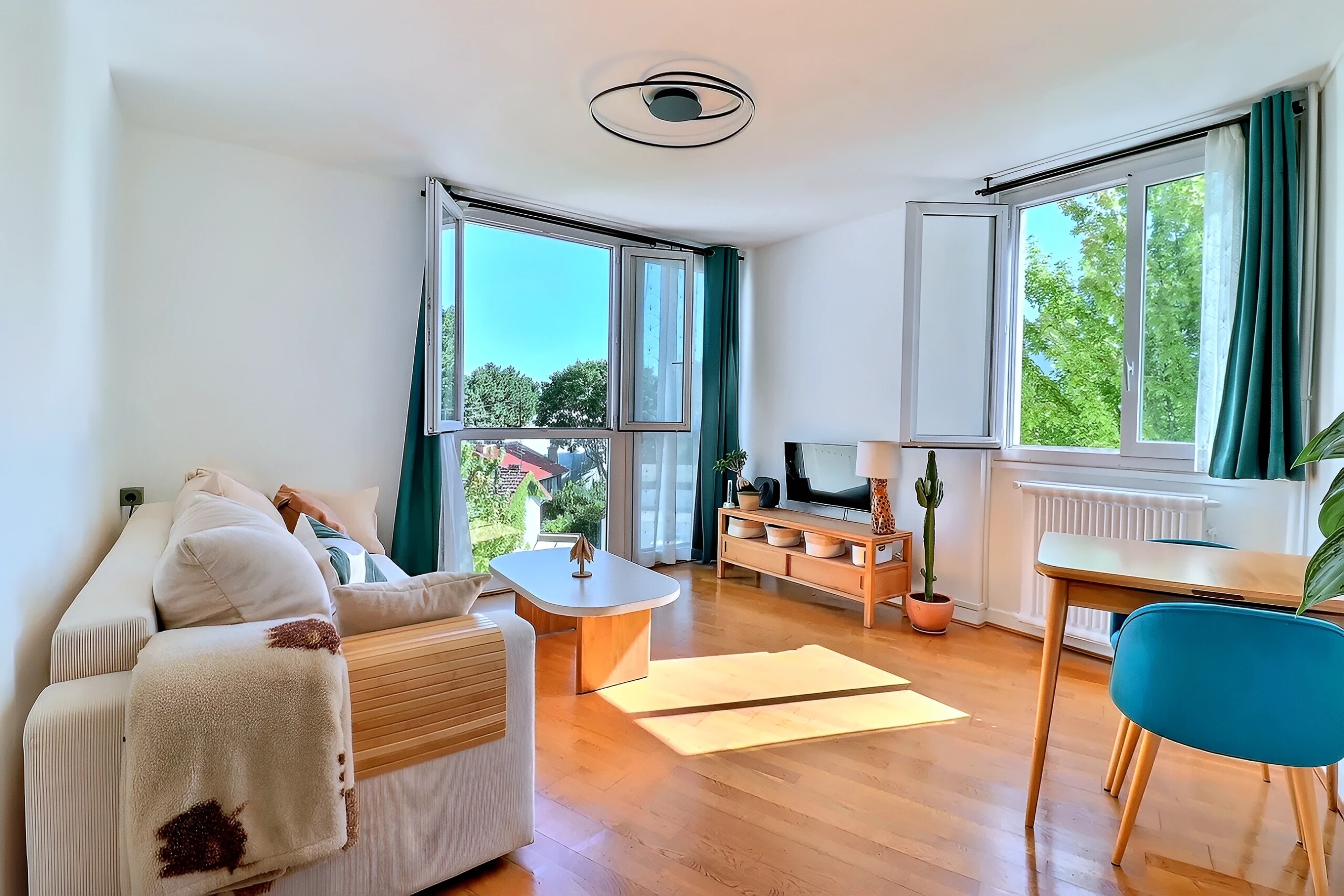 Séjour lumineux d’un appartement à Meudon Val-Fleury avec deux grandes ouvertures et vue dégagée sur la verdure