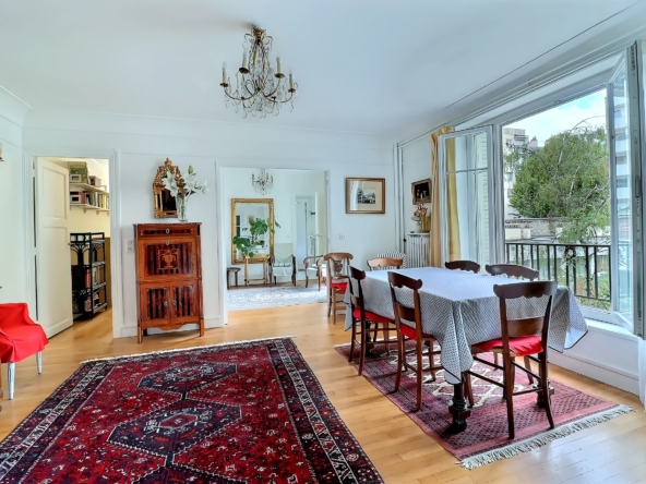 Salon avec parquet, miroir ancien et fenêtre ouverte sur les jardins du square Charles Laurent à Paris 15e